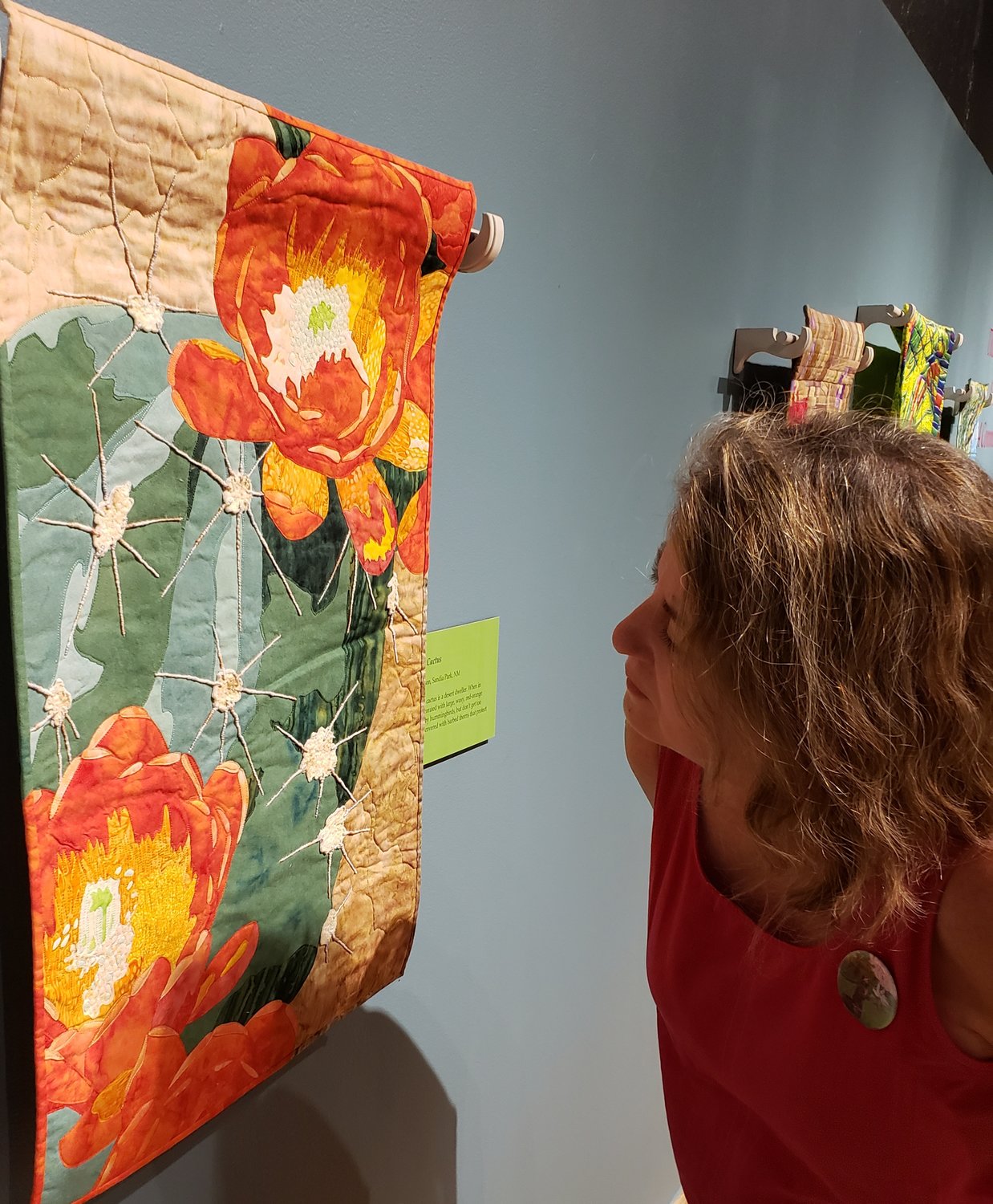 Tauna gets really up close and personal with the Claret Cup Cactus quilt, noticing how the quilter embroidered with yarn to create the spines.