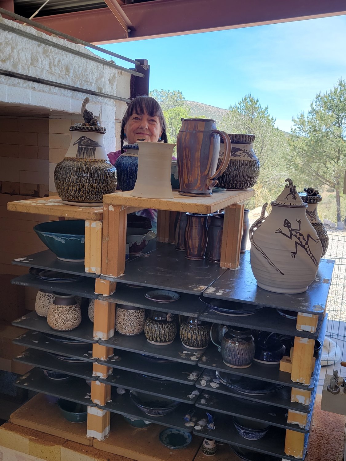 Letha Cress Woolf unloads her cone 10 gas reduction kiln at her Studio in Wind Canyon.