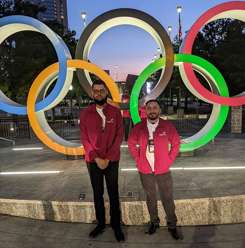 Kyros Ervin (L) and Allen Gonzalez (R) stand in front of the Olympic circles at the Centennial Olympic Park, next to the competition venue.