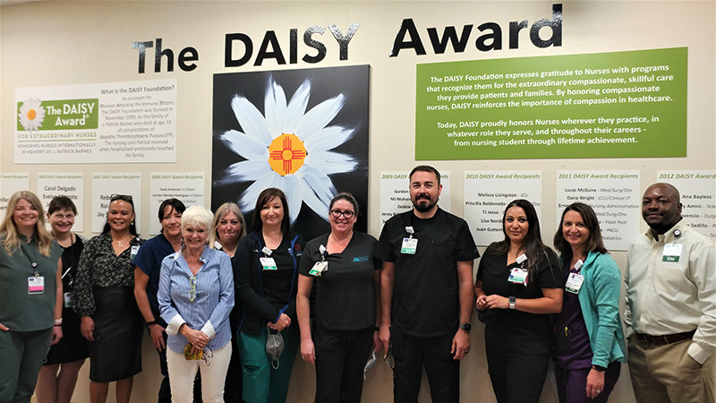 Memorial Medical Center staff and Las Cruces artist Cynthia De Lorenzi, center left in the blue shirt, unveiled The Daisy Wall Aug. 25 at the hospital.