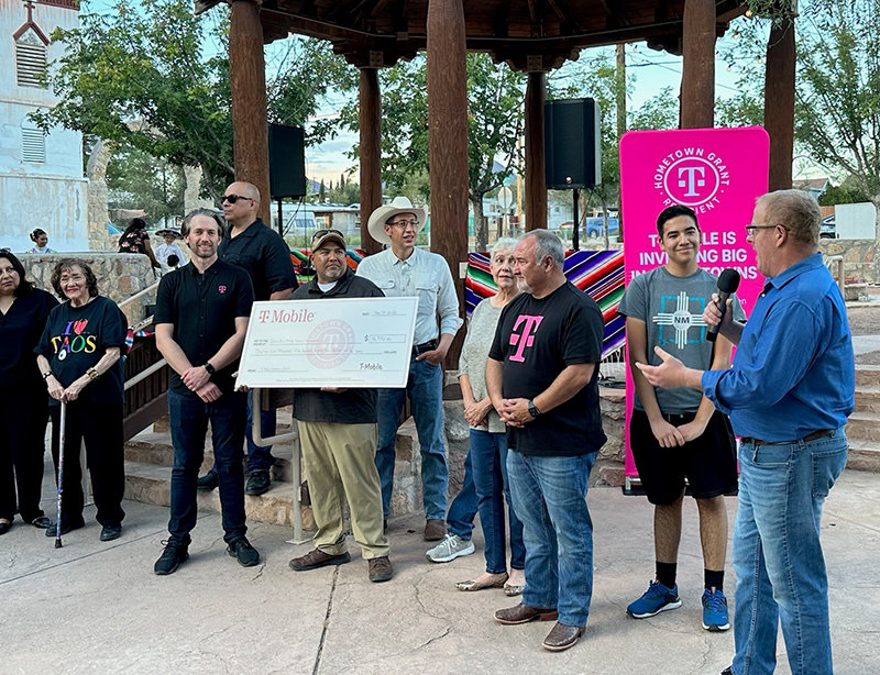 Sen. Jeff Steinborn helps to present the T-Mobile grant to the Village of Doña Ana Saturday, Sept. 24.