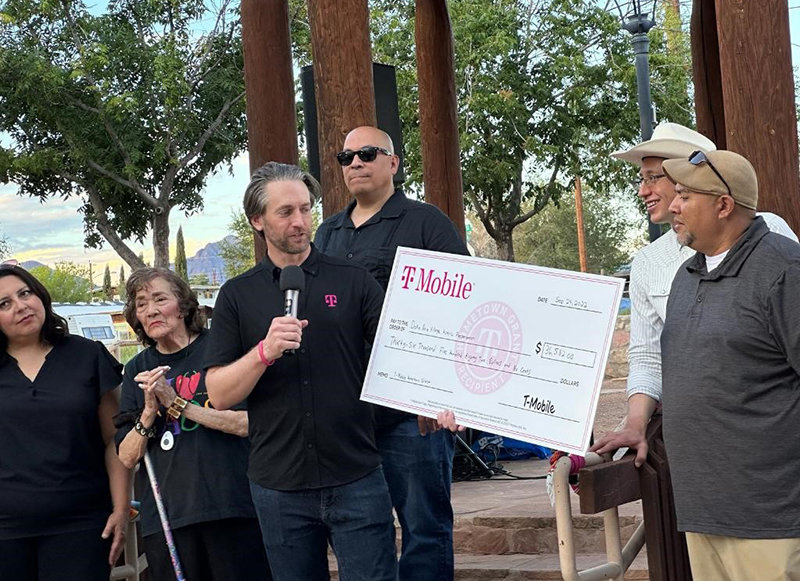 A representative of T-Mobile presents a check to the Village of Doña Ana to spruce up the village’s historic plaza. To his left is Doña Ana resident and former state senator Mary Jane Garcia.