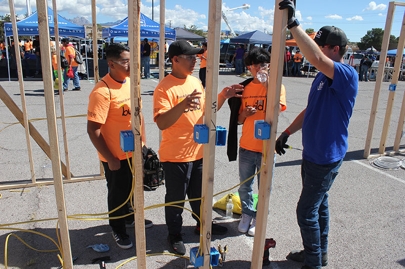 Jeremiah Ogas, Nathan Sanchez and Leo Caldera of Organ Mountain High School visit with Cole Sattler, a superintendent with IES Residential, an electrical company. Sattler talked with them about the work of a journeyman electrician at the Oct. 11 Build My Future event.