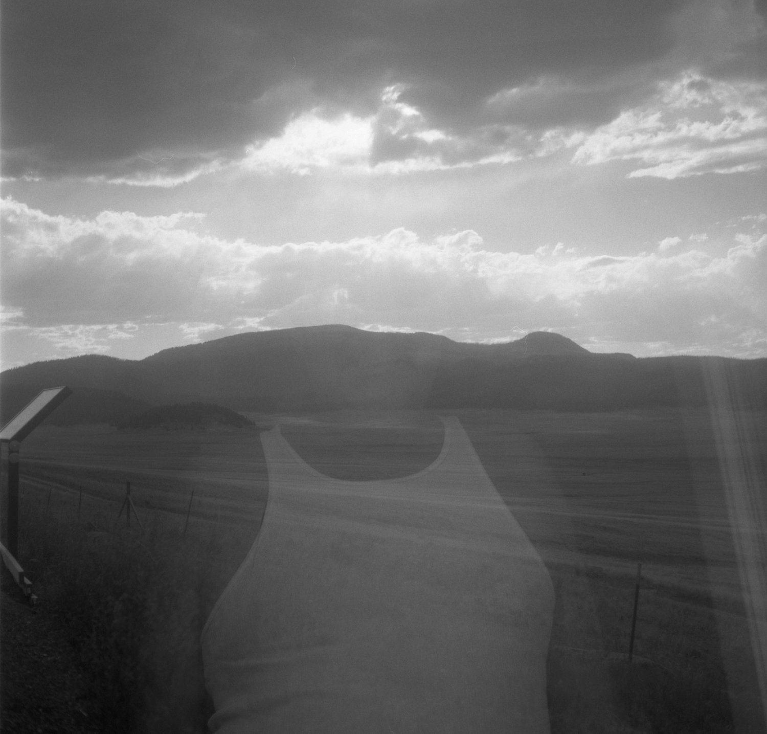 “I love you, mucho mucho” by Maryssa Rose Chavez, 2020, black and white film image. “My dad at the front door double exposed over the Valles Caldera, northern New Mexico.”