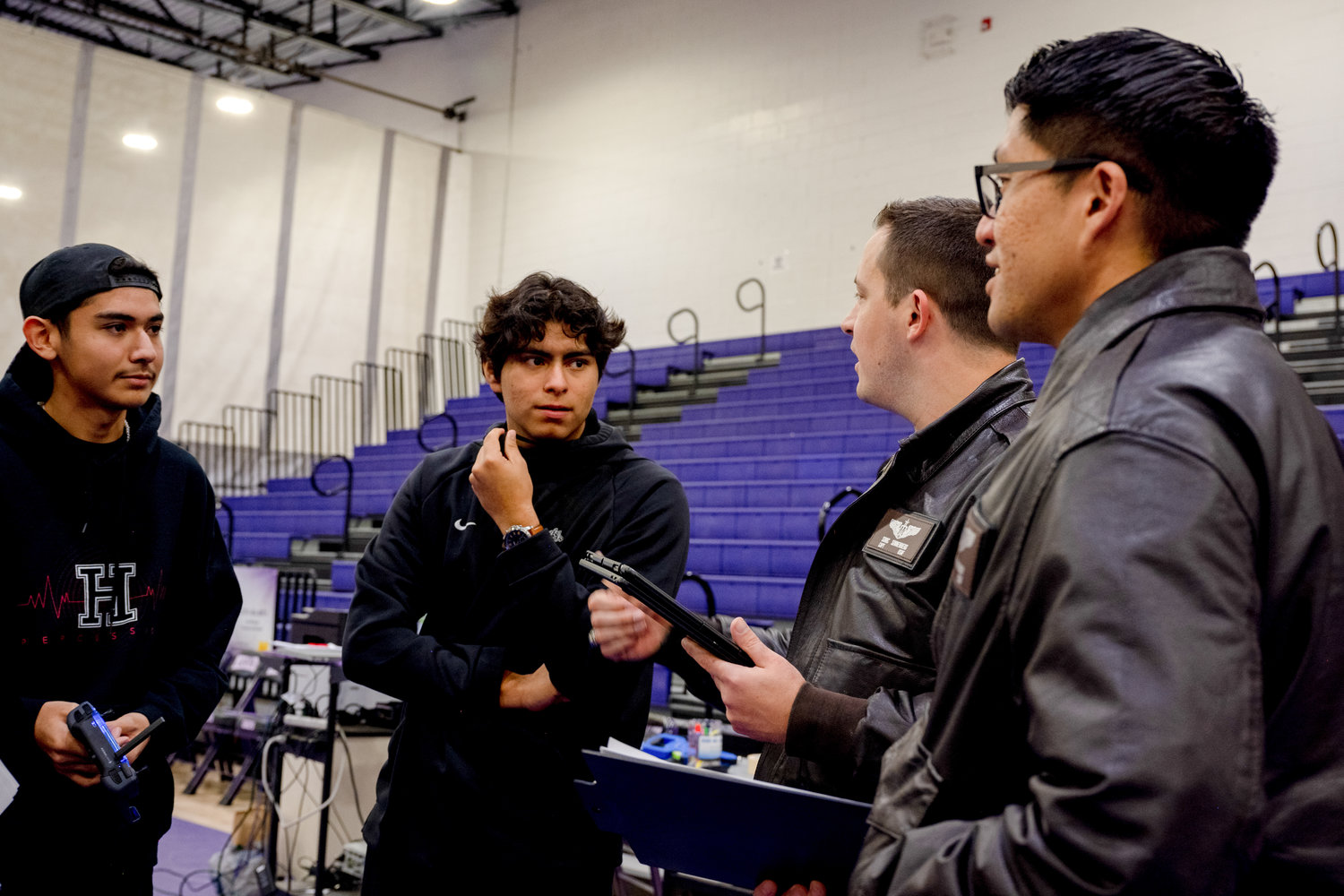 Airmen from the 29th Attack Squadron discuss the scoring process with students from the J.M. Hanks High School robotics team, out of El Paso, Texas, during the first Aerial Drone Competition at Mescalero Apache High School, Jan. 21, 2023. The 29th Attack Squadron served as judges and referees for this event, as well as mentors for the students, providing guidance throughout the competition. (U.S. Air Force photo by Senior Airman Antonio Salfran)
