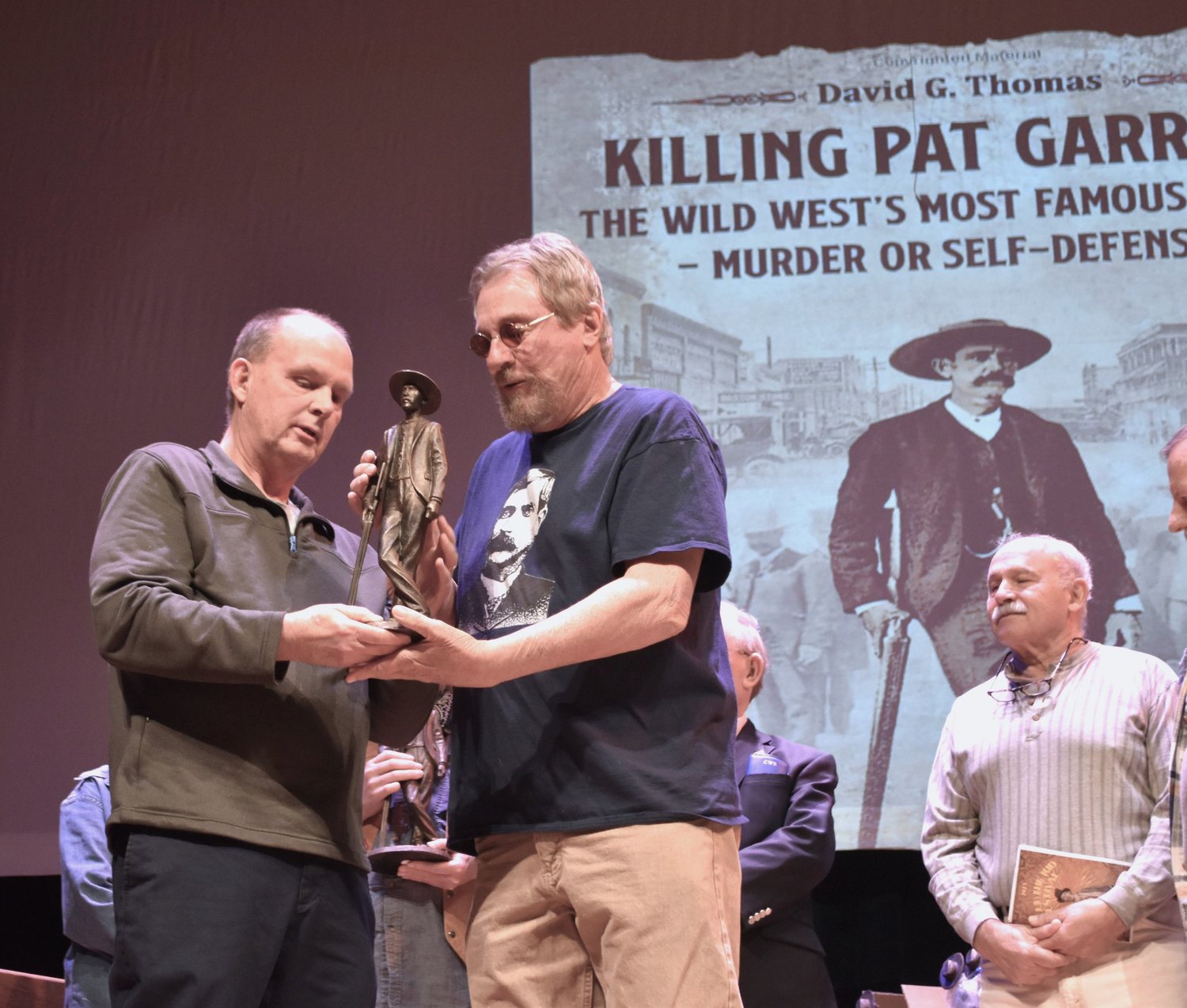 Pat Garrett’s grandson Scott Davis presents Dan Crow with a figuring of Garrett he had made for the group of historians known as the Friends of Pat Garrett.