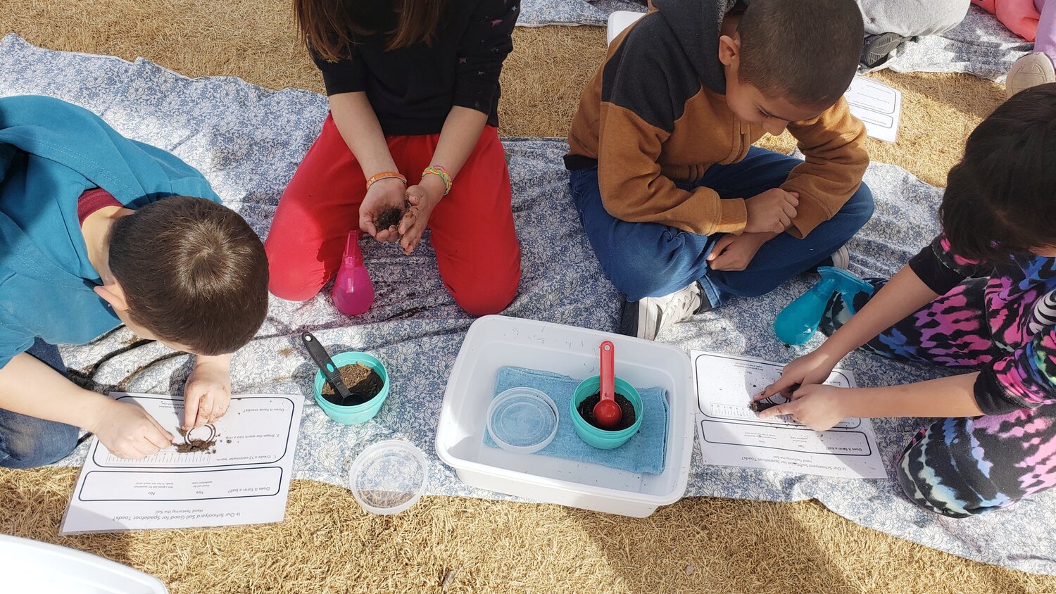 Central Elementary second graders practicing "hand texturing" soil to discover whether spadefoot toads have the correct type of soil to bury into under their playground.