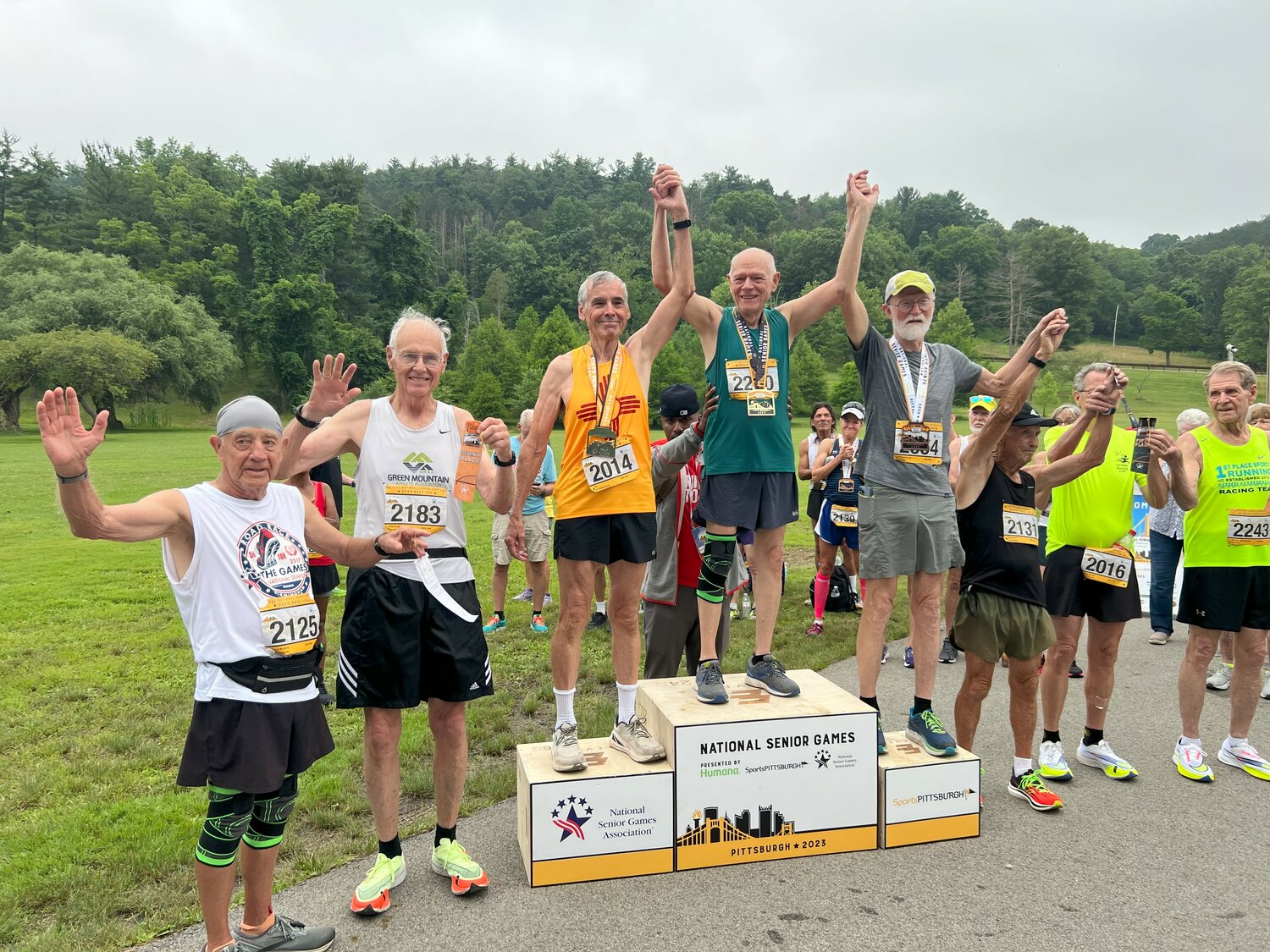 Al Berryman (in yellow Zia shirt) was second in the men’s age 80-84 10K Road Race in the 2023 National Senior Games July 7-18 in Pittsburgh, Pennsylvania. He finished with a time of just over 59:30. To Berryman’s left is Eric Yarborough of North Carolina, who won the race with a time just under 54:32. To Yarborough’s left is third-place finisher Franklin Crow of California, who finished with a time of just under 59:42.