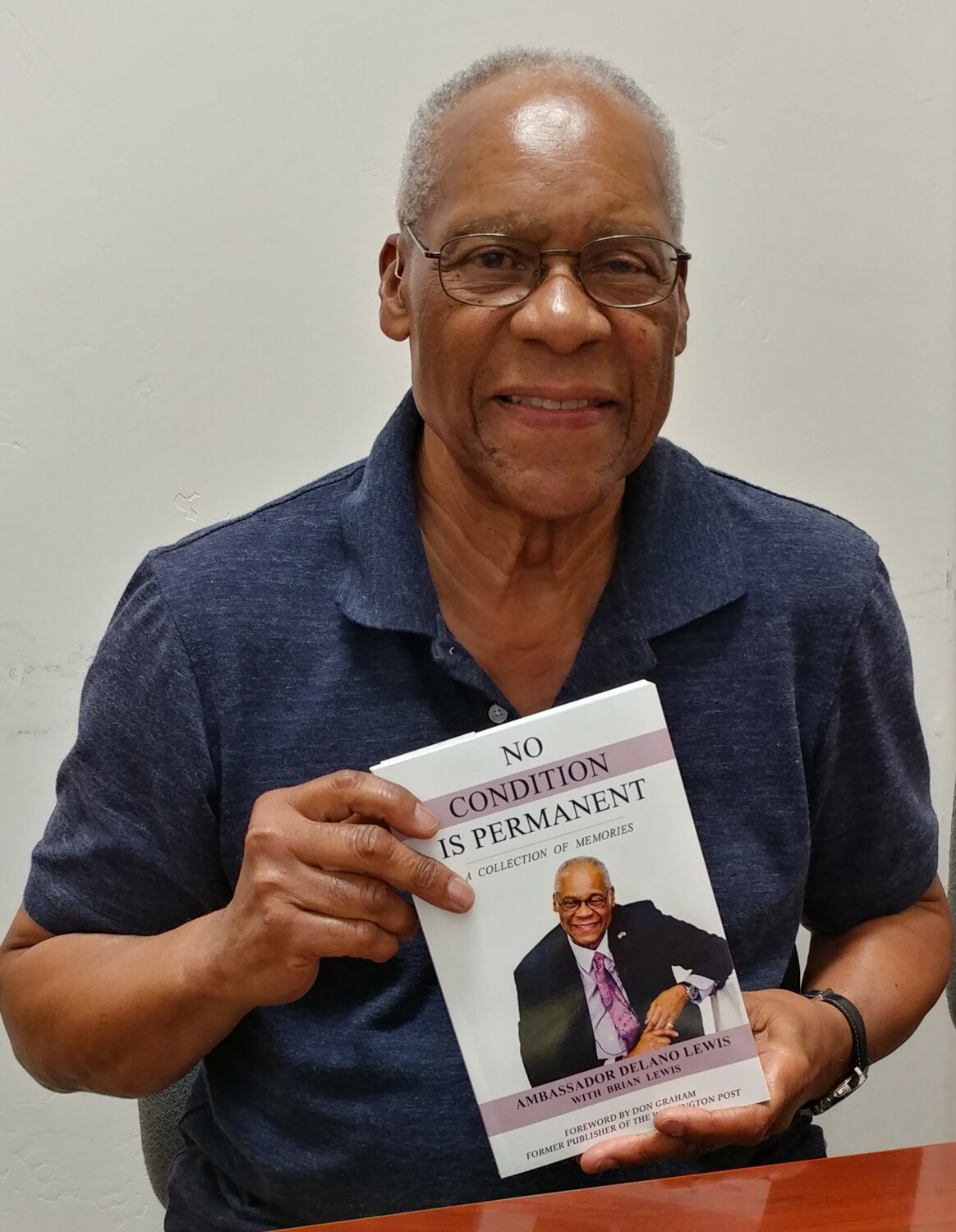 Retired ambassador and author Delano Lewis with his book, “No Condition Is Permanent: A Collection of Memories.”
