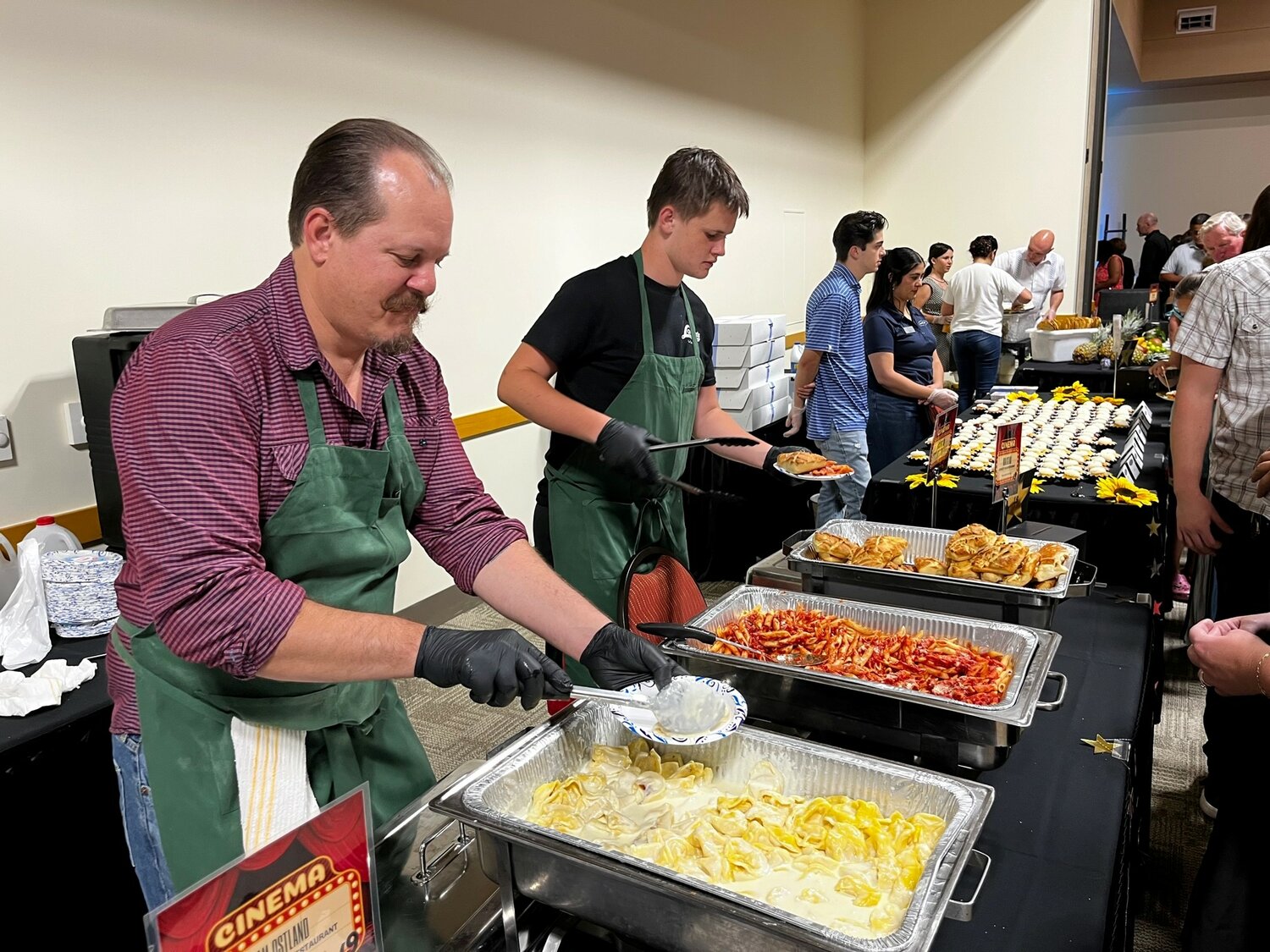 Adam Ostland and his son, Dean, of Lorenzo’s Italian Restaurant, dish up some tortellini and penne pasta at Men Who Cook.