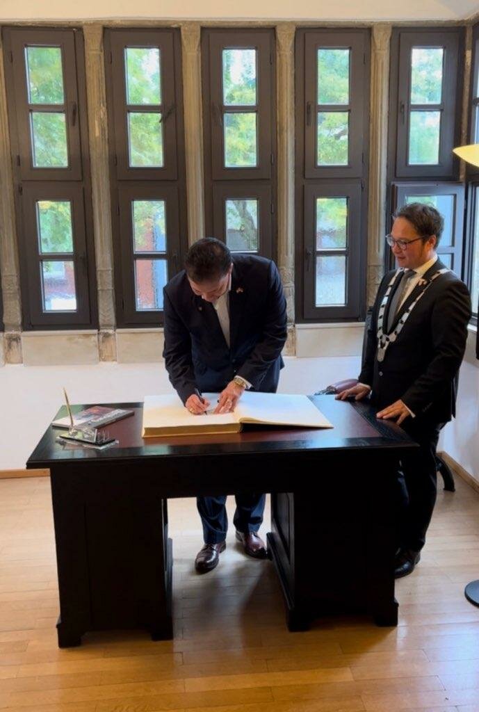 Mayor Ken Miyagishima signs the official registry at Nienburg City Hall.