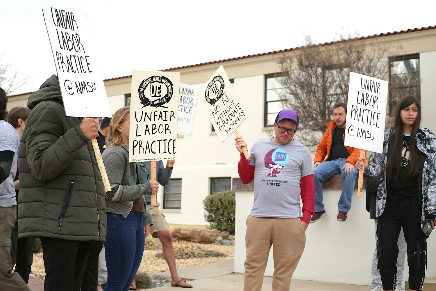 About two dozen graduate student workers rally at New Mexico State University's Hadley Hall on Feb. 6, 2024, after a labor board sustained a prohibited practices complaint the union filed against the university.