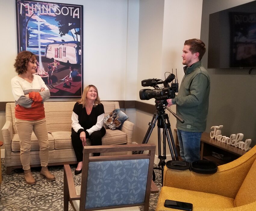 KTTC Rochester's news personality, Matt Rineer (R) chats with Goodhue Living staff, Susie Matthees (L) and Missy Shaleen while setting up video equipment to tape a segment on the Dare to Dream program.