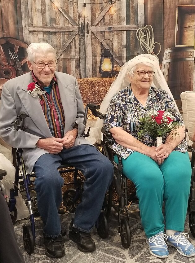 Don Reese in the suit jacket he wore for his wedding and Lila in her veil posing for pictures in front of a Western backdrop in the activity room of Goodhue Living where they have resided for the past year.  The surprise chivaree was a Goodhue Living Dare to Dream event.