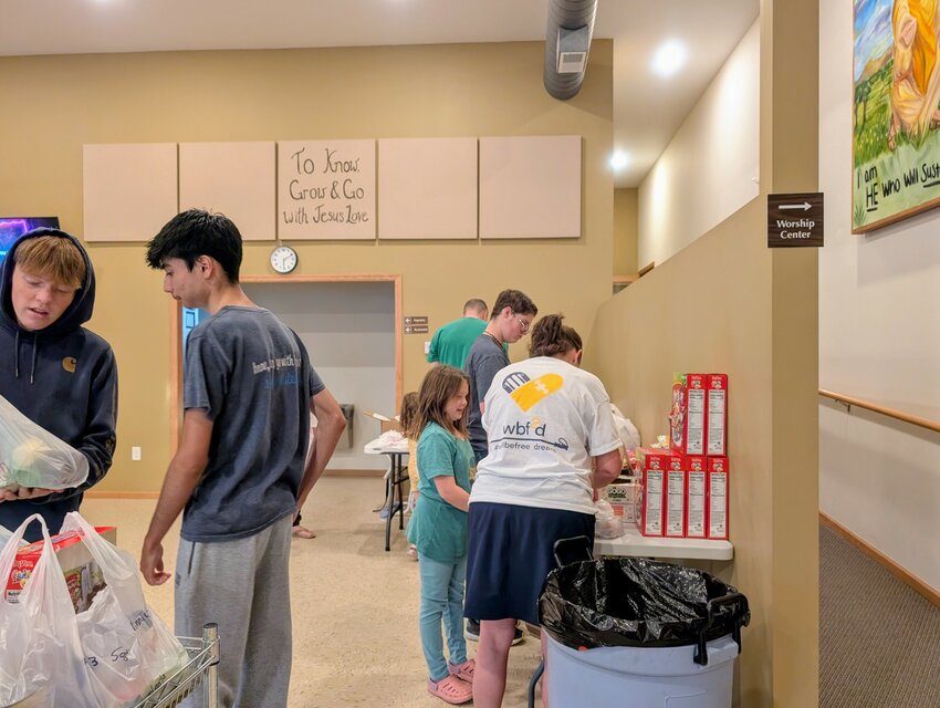 Youth group helping the younger ones to fill the food bags for PEM Backpack for Food program