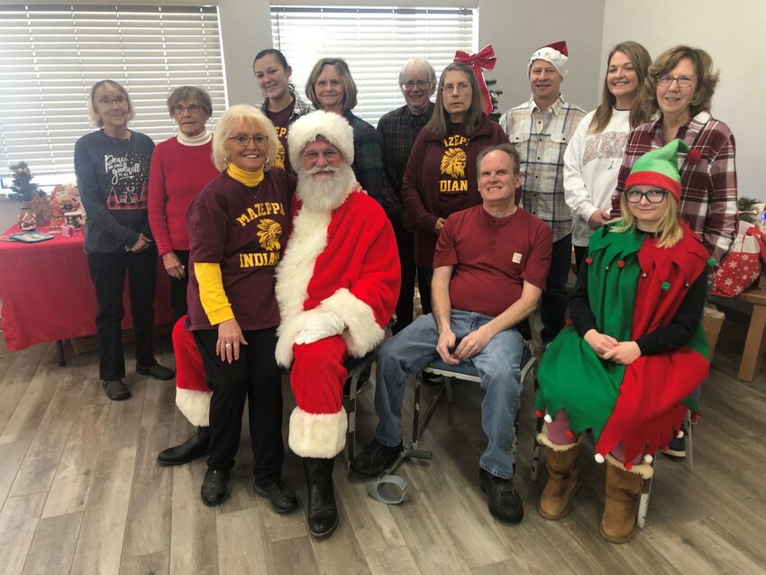 From left to right are Betty Baer, Dora Hellerud, Helen Reiland, Kenna Bishop, Santa Claus (Kevin Ewert of Rochester), Faye Gabrielson, Bill Marx, Candy Marx, Tom Stahman, Bob Perrotti, Callie Markson, LuAnn Lewer and Santa&rsquo;s elf, 16-year-old Olivia Markson. All are MAHS members except for Olivia Markson, Kenna Bishop, and Santa Claus.