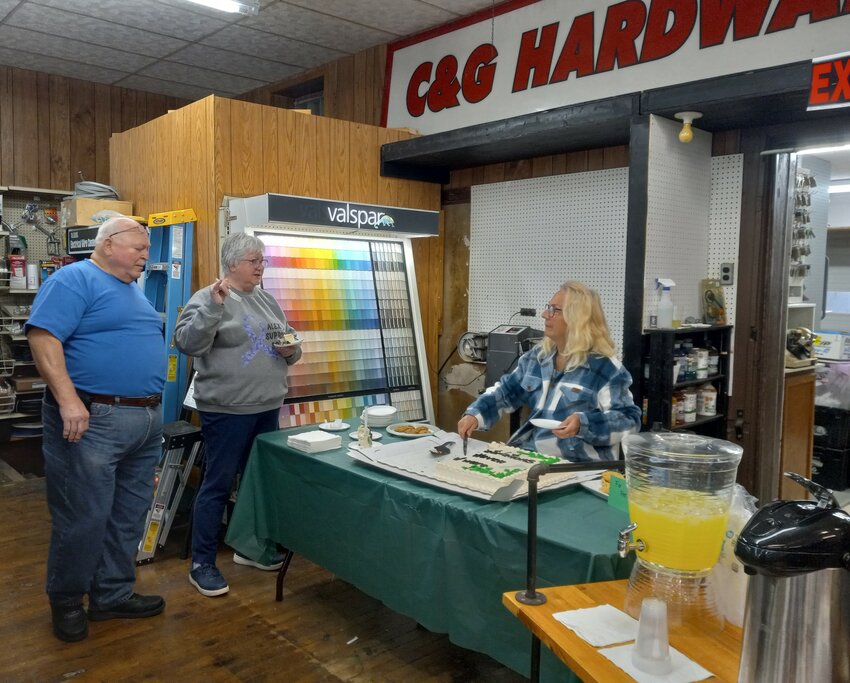 Becky Hadler-Phernetton serves cake to Wayne and Marilyn Schilling during the Vine Haven Hardware store's grand opening celebration.