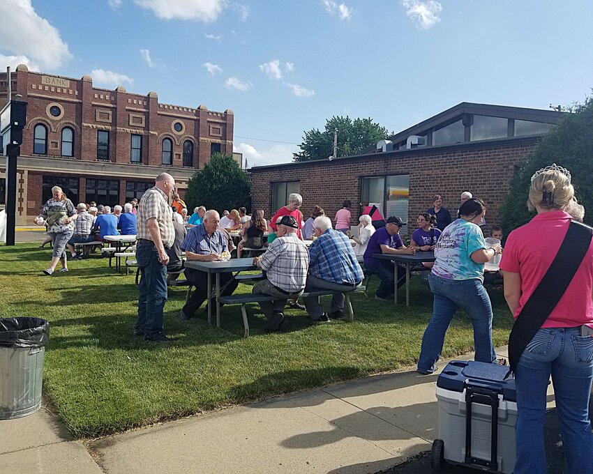 Many people socialized outside Goodhue's First Farmers and Merchants Bank during their June 10th appreciation event. The 5 PM promotion avoided storms that threatened later in the evening, allowing everyone to enjoy the hot dogs, chips, cookies and dairy treats.