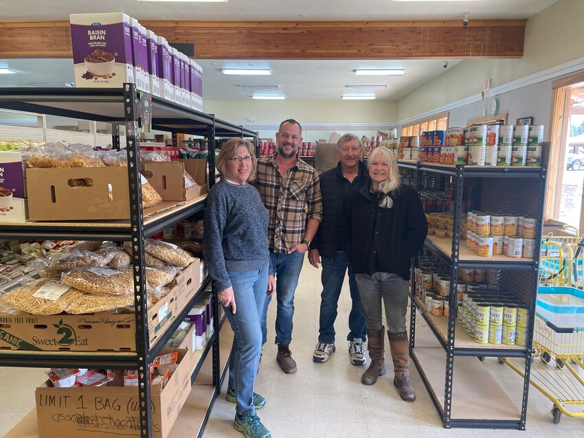 Our Community Eats food pantry volunteers stand together in the pantry’s shopping aisle on Friday, May 10, before opening for the day. Pictured, left to right, are Paula Craig, Loren Talley, Doug Baxter and Lindy Porter.