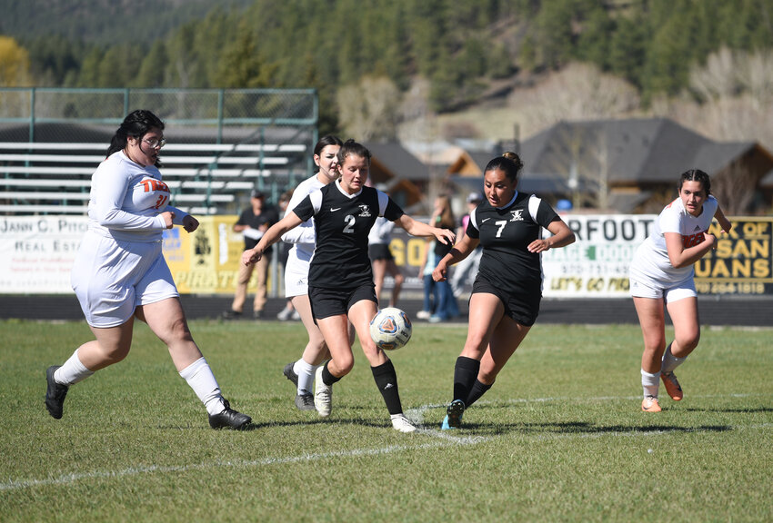 Pagosa player Lauren Monterroso works to move the ball forward with Elizabeth Currier during a game against the Del Norte Tigers at home on April 30. Monterroso led the team by scoring four goals in the game, with Currier following with three.