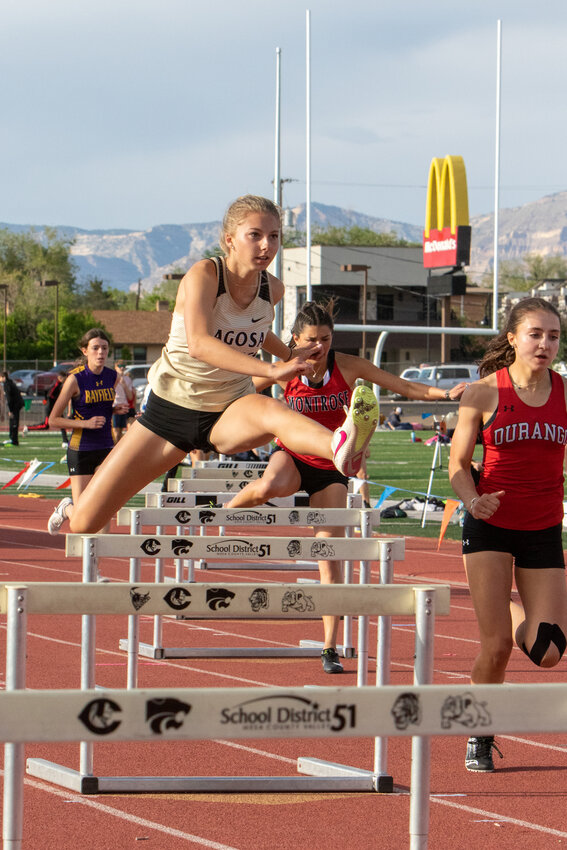 Lady Pirate Kylie Ketchum eyes the finish line while clearing a hurdle at the Dennis Teeters Tiger Invite in Grand Junction. The Lady Pirates took fourth at the meet.