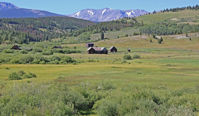 Abandoned Ranch buildings sit above a meadow of Deer Creek south of Anaconda, Mont., in late July.