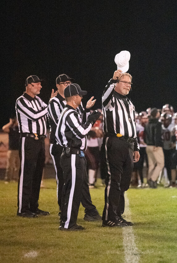 Longtime referee Neil Stock tips his hat to the crowd before the Oct. 16 football game at Golden Peaks Stadium. Stock was honored and thanked following the announcement that Stock will be retiring from on-field duties after 30 years as a referee with that night&rsquo;s game. &ldquo;His service to Colorado during those 30 years include officiating somewhere between 700 and 800 games, 60 to 70 playoff games and selections by CHSAA leadership for two state championships,&rdquo; the tribute stated. Stock will continue as a mentor and trainer for new officials.