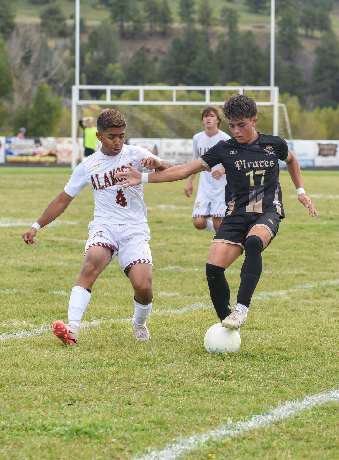 Gavin Carter shields the ball from an Alamosa defender on Saturday, Sept. 21. The match ended in a tie with a score of 1-1.