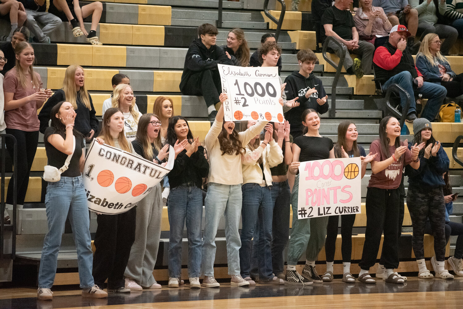 Lady Pirate fans hold up signs congratulating Elizabeth Currier on Saturday in Pagosa Springs. Currier scored her 1,000th career point during the team’s 53-27 victory over the Ignacio Bobcats.