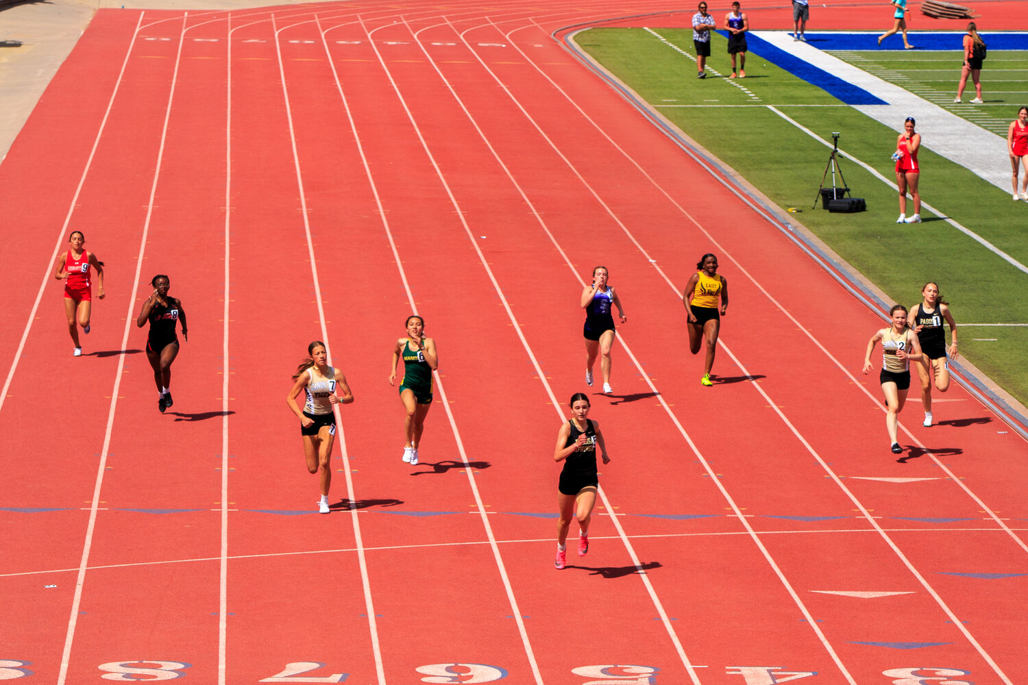 Lexi Campbell, center, and Molly Washburn, right, run in the 200-meter dash at the April 12 Thunder-Storm Invitational in Pueblo.