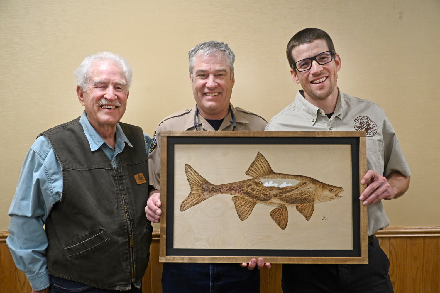 Daniel Cammack, who grew up in Pagosa Springs, is presented with Colorado Parks and Wildlife’s Outstanding Biologist of the Year. Cammack is CPW’s Southwest Region native aquatic species biologist. At the ceremony Aquatic Wildlife Branch Assistant Director Matt Nicholl presented Cammack with a wood burned art piece of a roundtail chub. Attending the ceremony were Cammack’s uncle, CPW Southwest Region Senior Aquatic Biologist James N. White and Cammack’s grandfather, James R. White. According to CPW, Cammack has long been a critical member of the CPW staff for his conservation work with our native aquatic species such as boreal toads, roundtail chub, bluehead sucker, flannelmouth sucker and Rio Grande chub and sucker. He also contributes to work with native cutthroat trout species. An email from the agency notes, “Cammack’s work has been critical, highlighted in last year’s decision by the U.S. Fish and Wildlife Service [USFWS] to not list Rio Grande chub and sucker under Endangered Species Act protections. He works tirelessly with partners from the USFWS, New Mexico, National Park Service and numerous other partners on the conservation of those species and to increase their populations in their historical waters.”