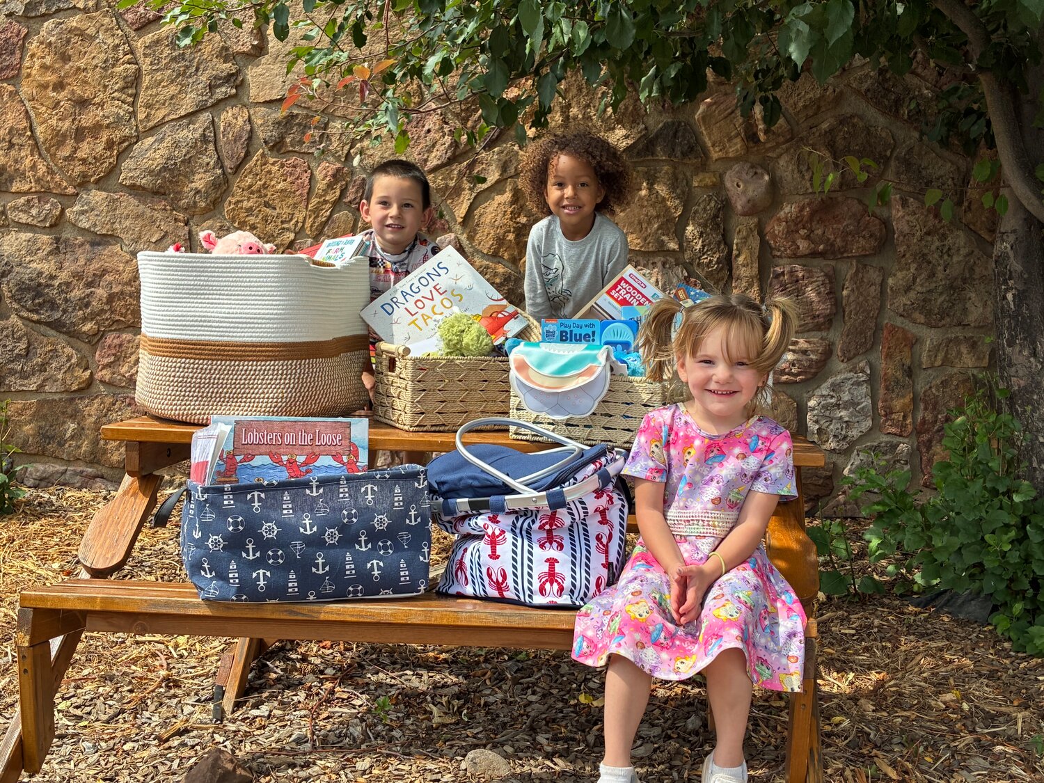Gabe, Malcomb and Violet show off some book baskets to be auctioned off in the &ldquo;A Tisket, a Tasket Story Time&rdquo; basket campaign for the Wings in the Wild fundraiser this month.