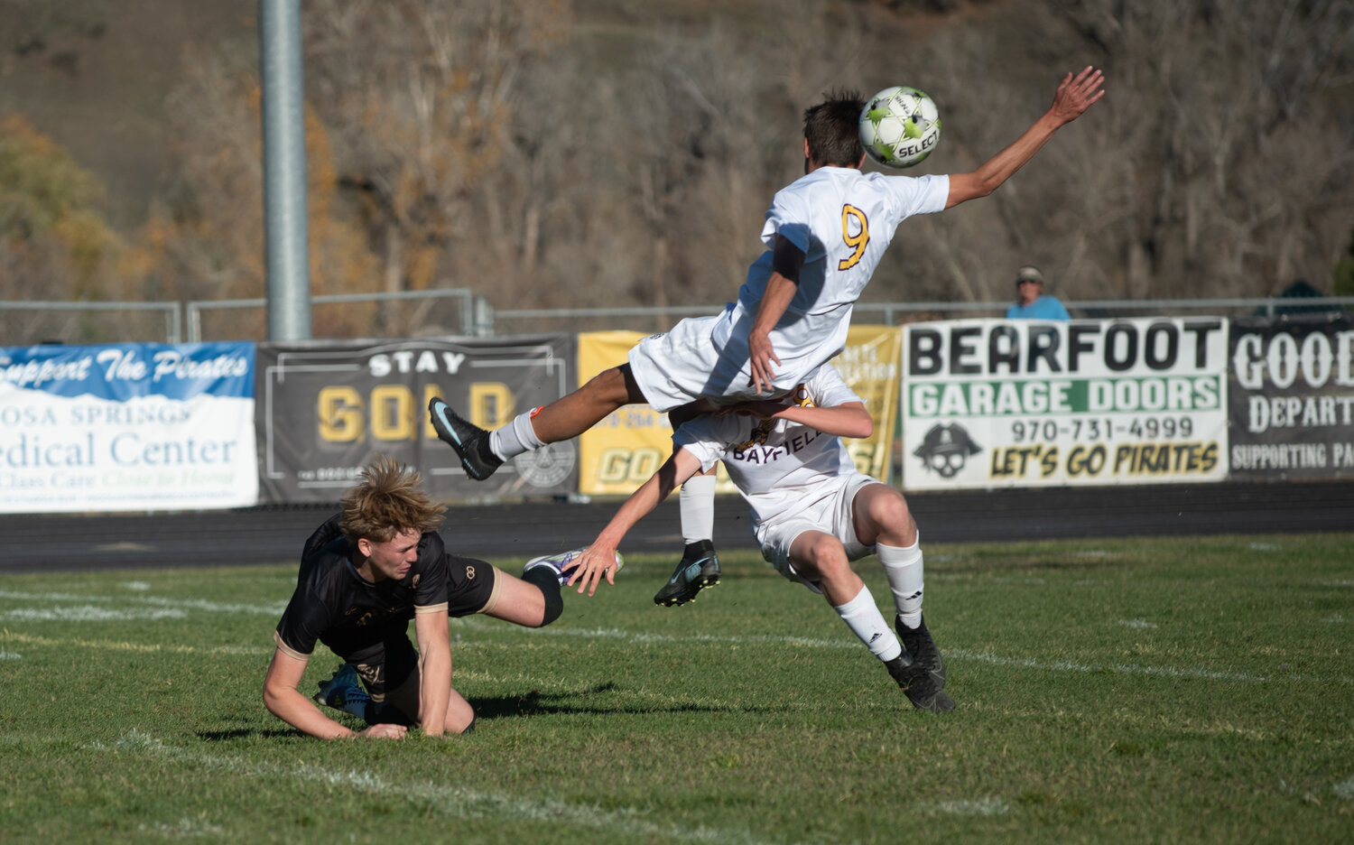 Ryder King falls during a kerfuffle with a pair of Bayfield defenders. King scored two goals in the Pirates&rsquo; draw against the Wolverines, securing the team&rsquo;s second consecutive Intermountain League title.