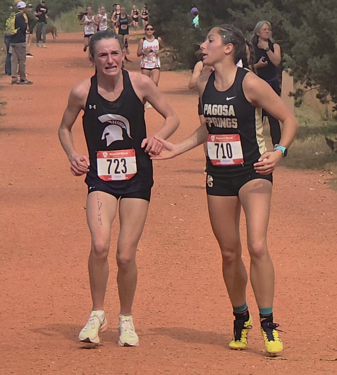 Lady Pirate Madisen Stretton encourages a fellow runner during the Oct. 23 regional meet. Stretton stopped to help the runner, who had fallen, then ran the rest of the race with her.