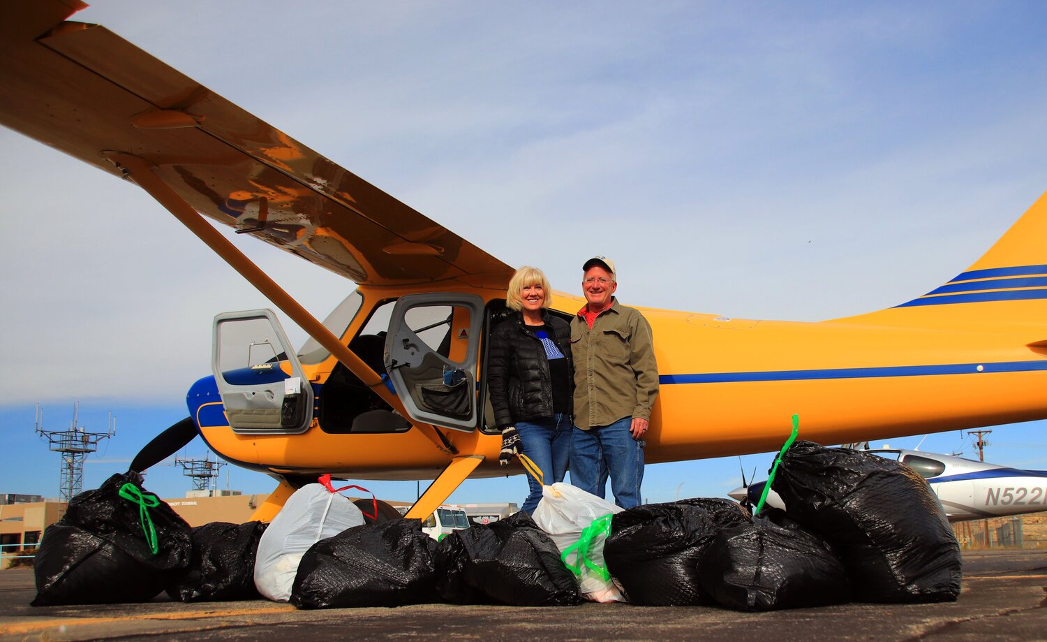 Krissy and Mark Guenin stand by their plane, surrounded by blankets and clothes they delivered to the Navajo Nation in Gallop, N.M., recently. For several years, several pilots from Pagosa Springs have participated in the Navajo Nation Christmas Airlift, which delivers donated household goods to the Navajo Nation for the needy in their community. The effort delivered approximately 18,000 pounds of donations over three days. The Navajo Nation Christmas Airlift is in its 41st year.