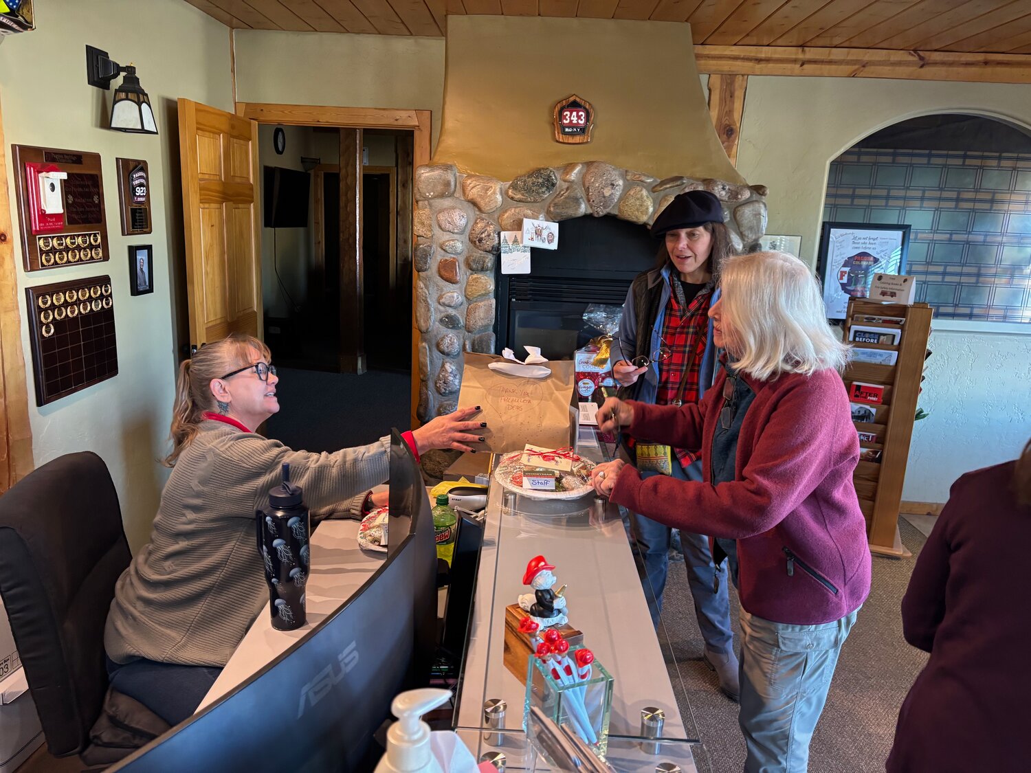 Volunteers with the Archuleta County Democrats baked dozens of holiday cookies and delivered them last week to public offices, first responders and others in the community who serve Pagosa Springs. Pictured are Isabelle Emerson and Candace Jones delivering cookies to the Pagosa Fire Protection District office. Other members of the Dems cookie brigade include Jules Graeve, Florence Hall, Kathy Keyes, Paula Miller, Charleen Stipe, Lee Stopher and Sue Watson.