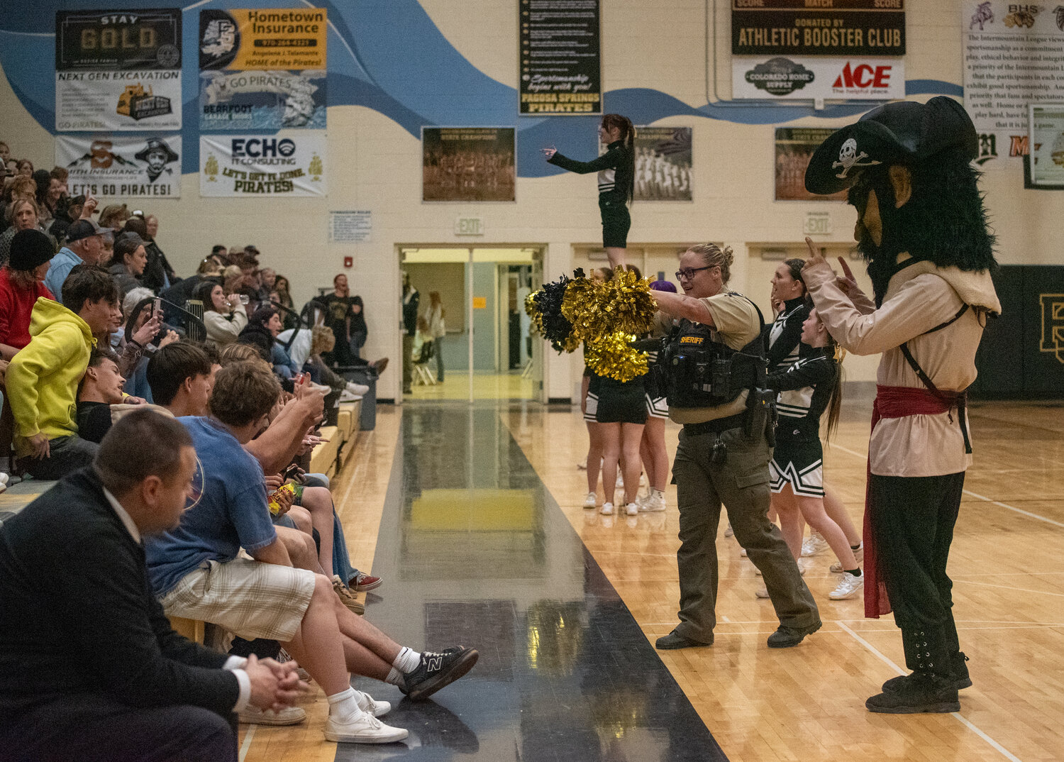 The Pagosa Springs High School Pirate cheer squad receives a little help from Deputy Dylaina Gauvey, one of the school&rsquo;s resource officers, at Tuesday evening&rsquo;s basketball games.