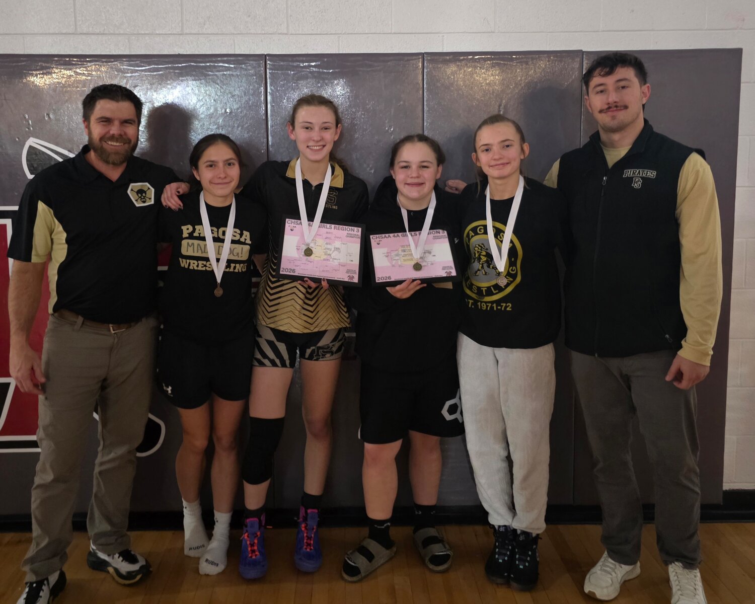 Four Lady Pirate wrestlers pose after earning the opportunity to compete at the state tournament beginning today, Feb. 19, in Denver. From left to right are coach Nate Stretton, Madisen Stretton, Kyley Matyniak, Laykyn Baxstrom, Bella Jackson and coach Caleb Janowsky.