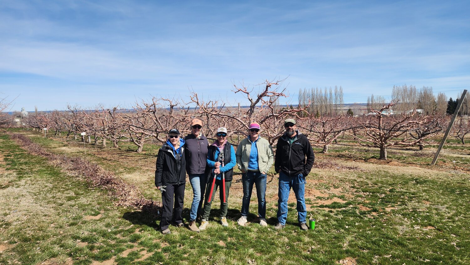 From left to right, Anna Schneider, Sharon Dickson and Jane Weitzel, with workshop leaders Maddie Stevens and Gus Westerman at the Southwestern Colorado Research Center. The research orchard is behind them.