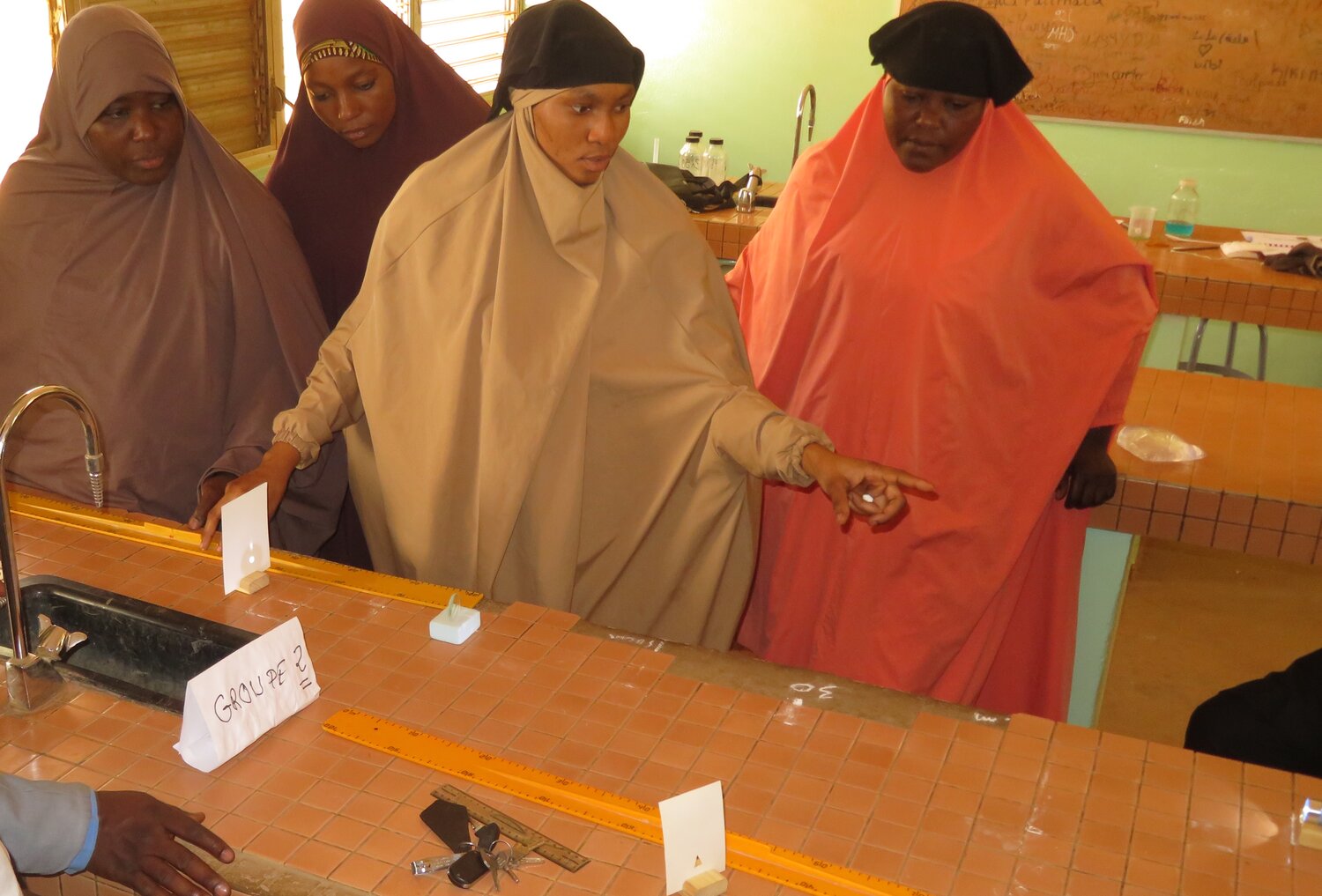 A physics teacher demonstrates how a double convex lens can be used to enlarge or reduce an image. Students pursuing a career in optometry need to understand the focusing properties of lenses.&nbsp;Photo from 2023 workshops in Niger.