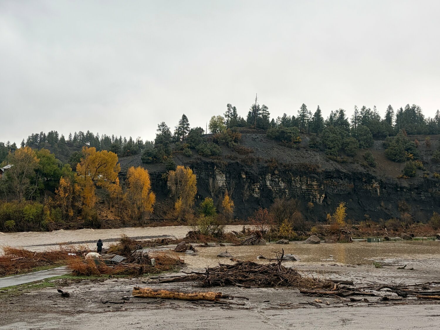 Debris sits after the Oct. 23 flood and the San Juan River flows near the U.S. 160 1st Street bridge and River Center Park at about 11:15 a.m. on Saturday, Oct. 24.