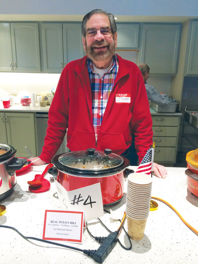 Each year, the North Bay Potluck group hosts a chili cook-off as part of more than 30 years of community building. Steven Gross shows off one of nine chilis in the competition.