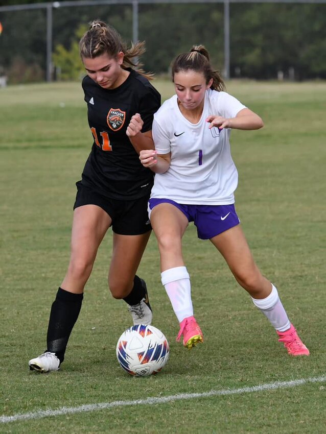 Ella McGeary (11) and Stevie Dickenson (1) battle for the ball.