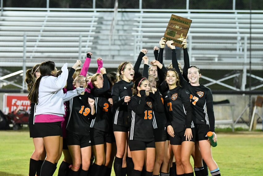 Cascade holds up the Region Champions plaque after Thursday's win.