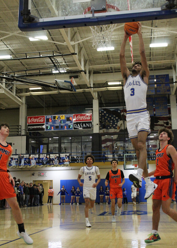 Senior Tae'Shawn Shelton (3) dunks home two of his 12 points in the win over Summit.
