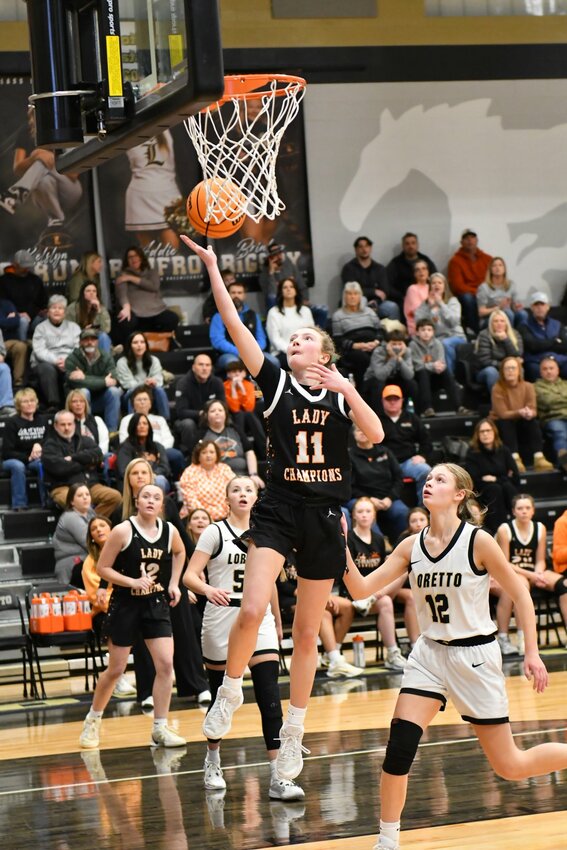 Lizzie Keele (11) lays in two of her 12 points at Loretto. Keele added six rebounds, three assists, and one steal along with pestering defense on the Lady Mustangs' Ally Augstin (12) all night long.