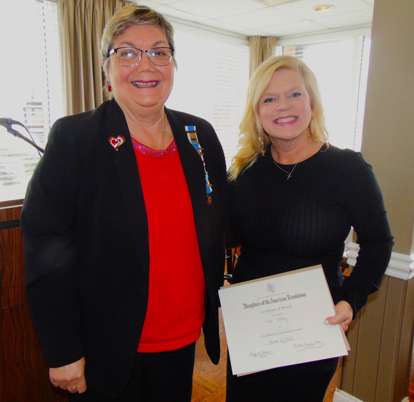 Tina Corley, right, accepts a community service award from Shelby DAR Treasurer - and her former French teacher - Maureen Garrett.