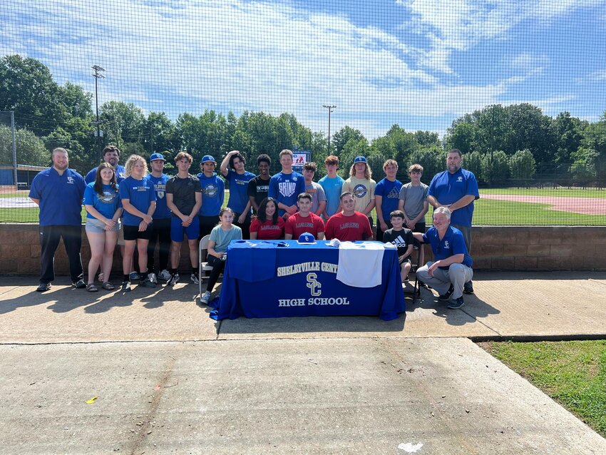 Nick Johnson (center, in red) is surrounded by his family, friends, teammates, and coaches after he signs with LaGrange College on Friday.