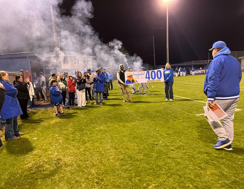 Friends, family, and parents await a smiling Chase Jones with firecrackers and a poster commemorating his career achievement following Tuesday's 11-1 win at Warren County.