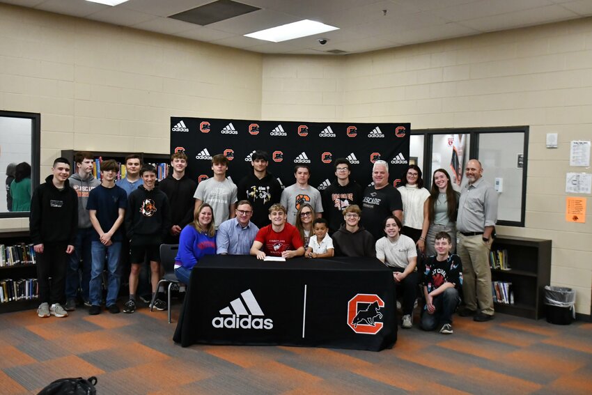 Vayden Moore (middle, red) officially signed with the University of The Cumberlands (KY) on Thursday to continue his wrestling career.
